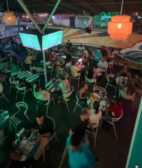 Ambiente nocturno en Ocio Gastropub en Santiago, con clientes en las mesas